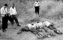 Efectivos policiales levantan los cadaveres de los hermanos Fadul y el de su chfer, Miguel Rivas.
